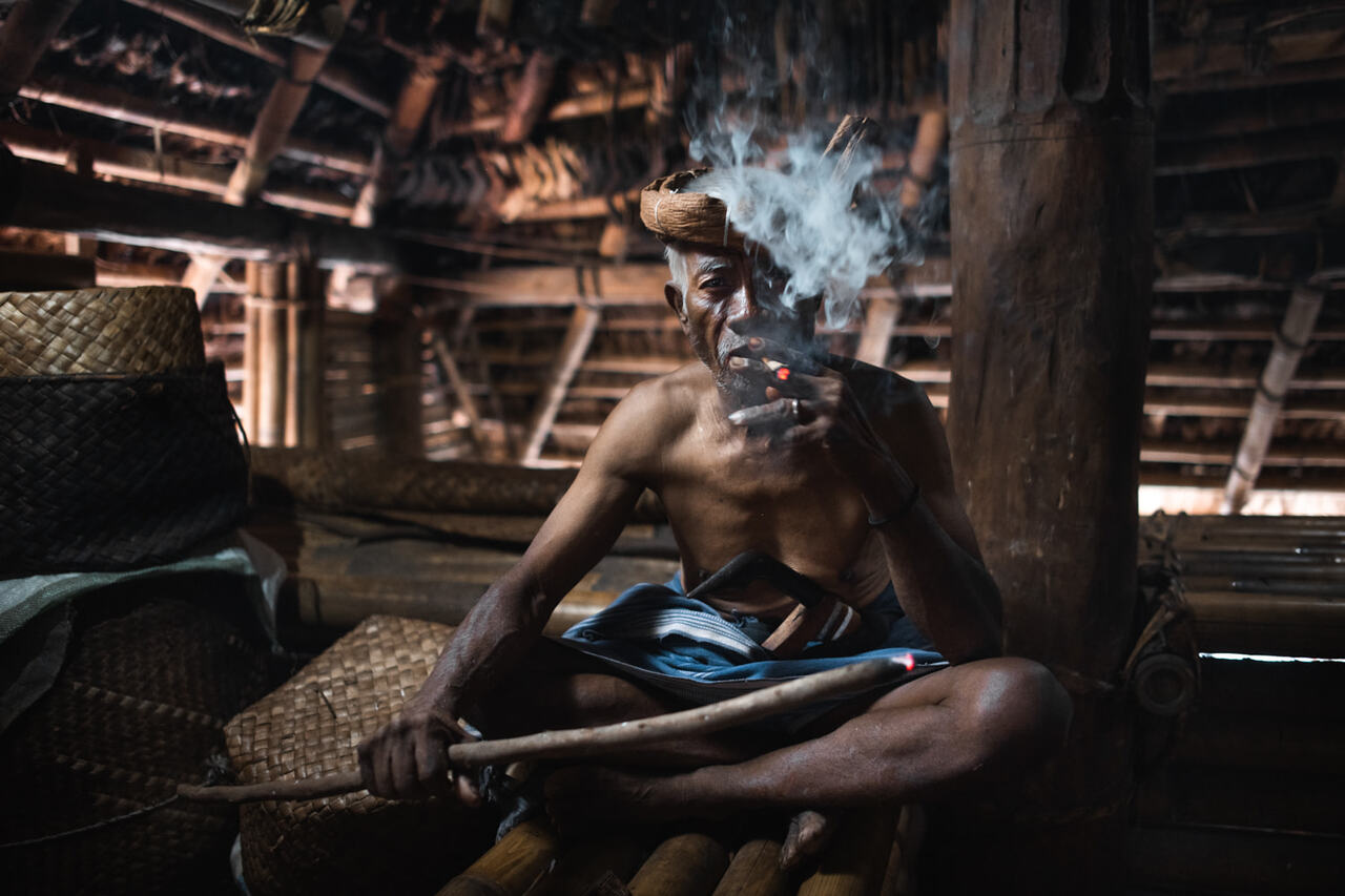 Sumbanese shamman smoking in traditional house